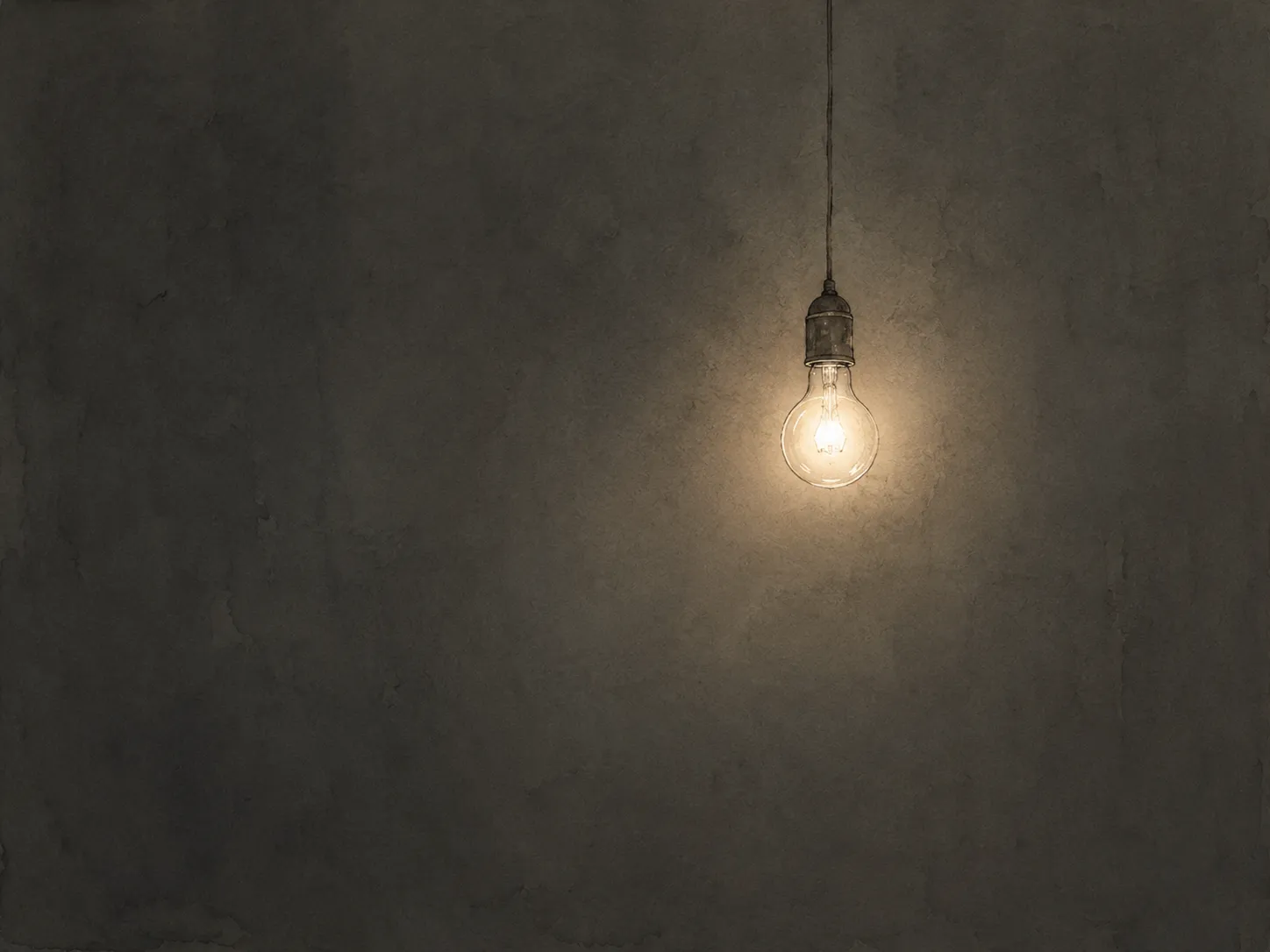 A single bare lightbulb on a cord, just switched on, glowing warm in an otherwise dark, empty space.